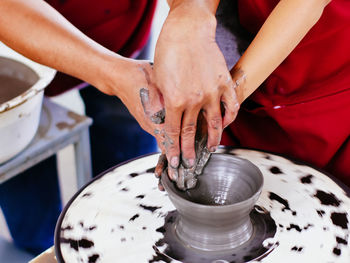 Close-up of people working in clay