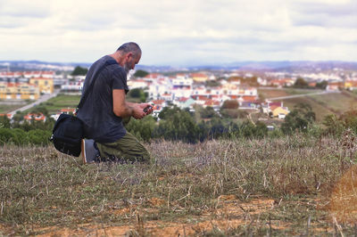 Side view of man sitting on field