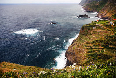 High angle view of rocky mountain by sea