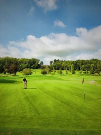 Man at golf course against sky