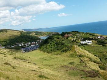 Scenic view of mountains and coastline against cloudy sky