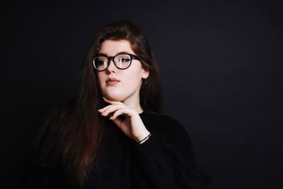 Portrait of a beautiful young woman over black background