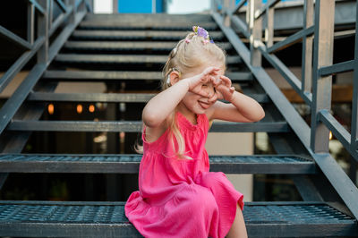 Portrait of young woman standing on steps