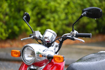 Close-up of wet motor scooter parked outdoors