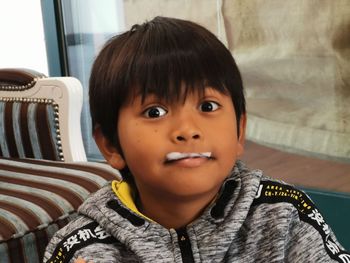 Portrait of cute boy with froth on lips at home