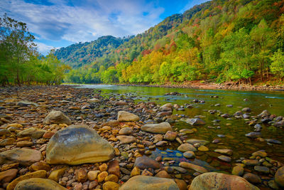 Stones by lake against sky