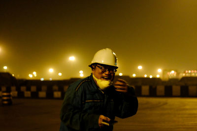 Man wearing sunglasses in city at night