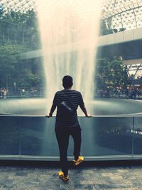 Rear view of man looking at waterfall