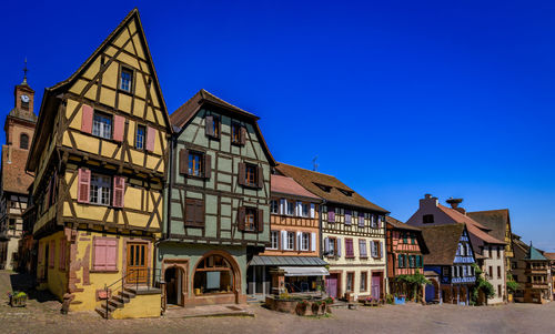 Low angle view of buildings against clear blue sky