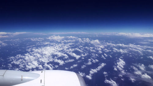 Aerial view of airplane wing over clouds