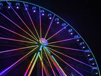 Low angle view of illuminated ferris wheel against sky at night