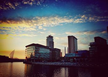 Sunset over river with buildings in background