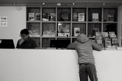 Rear view of man sitting on table