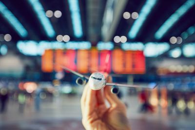 Cropped hand of person holding toy airplane