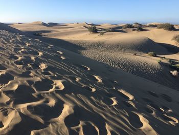 Sand dunes in desert against sky