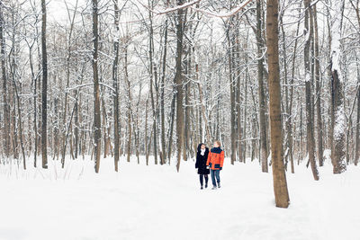 Rear view of people on snow covered land