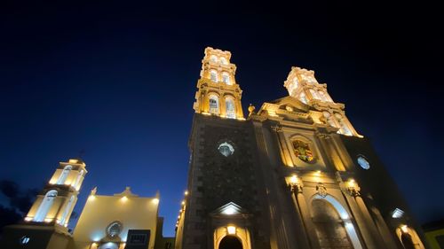 Low angle view of illuminated building against sky at night