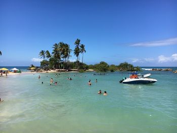 People on beach against blue sky