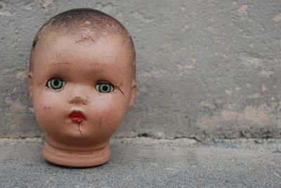 Close-up of doll head on wall