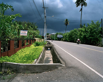 Empty road against cloudy sky