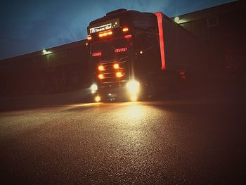 Cars on illuminated road against sky at night