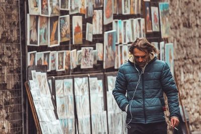 Man listening music while walking on street