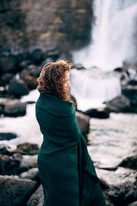 Rear view of woman standing on rock