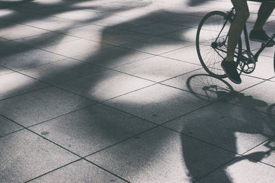 Low section of person cycling on footpath in city