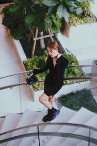 Portrait of young woman walking on staircase