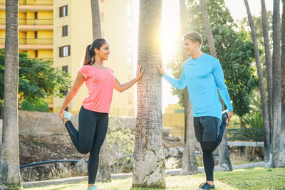 Smiling young couple exercising in park