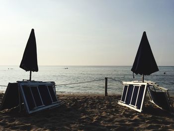 Lifeguard chair on beach against sky