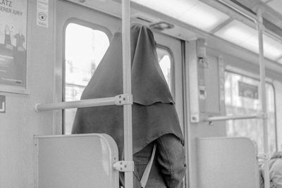 Rear view of woman standing in bus