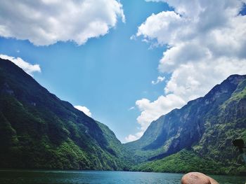 Scenic view of lake by mountains against sky