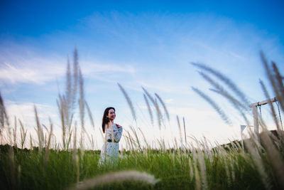 Woman standing on field against sky