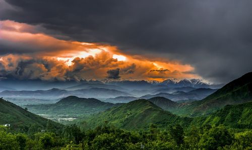 Scenic view of clouds over mountains during sunset