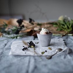 Hot chocolate in cup and food on tissue paper over table