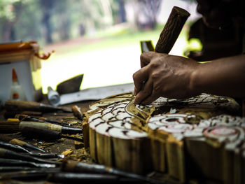 Cropped hands of man carving wood in workshop