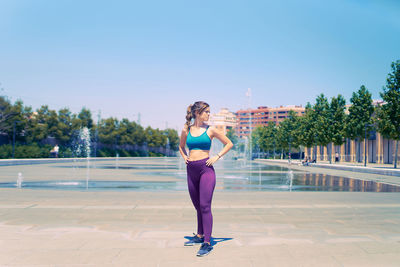 Sports model poses in sportswear looking to the side during a summer morning.