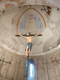 Low angle view of woman standing by ceiling