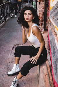 Portrait of beautiful young woman sitting in city