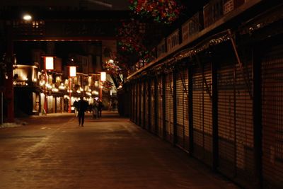 Woman walking in illuminated building at night