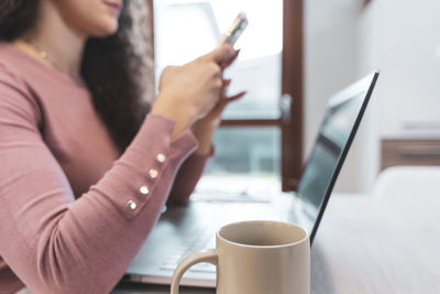 Midsection of woman using mobile phone