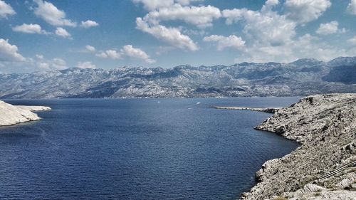 Scenic view of sea and mountains against sky