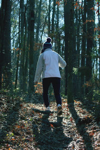 Full length rear view of woman walking in forest