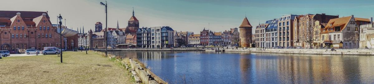 Panoramic view of river amidst buildings against sky