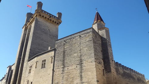 Low angle view of historic building against blue sky