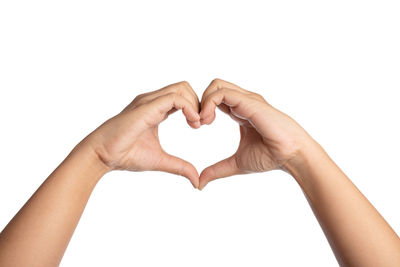 Close-up of woman hand holding heart shape against white background