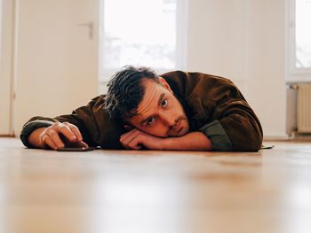 Portrait of young man lying on floor