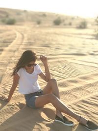 Woman sitting on sand at beach