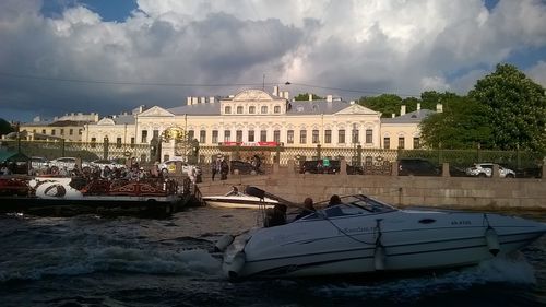 Panoramic view of boats in city against sky